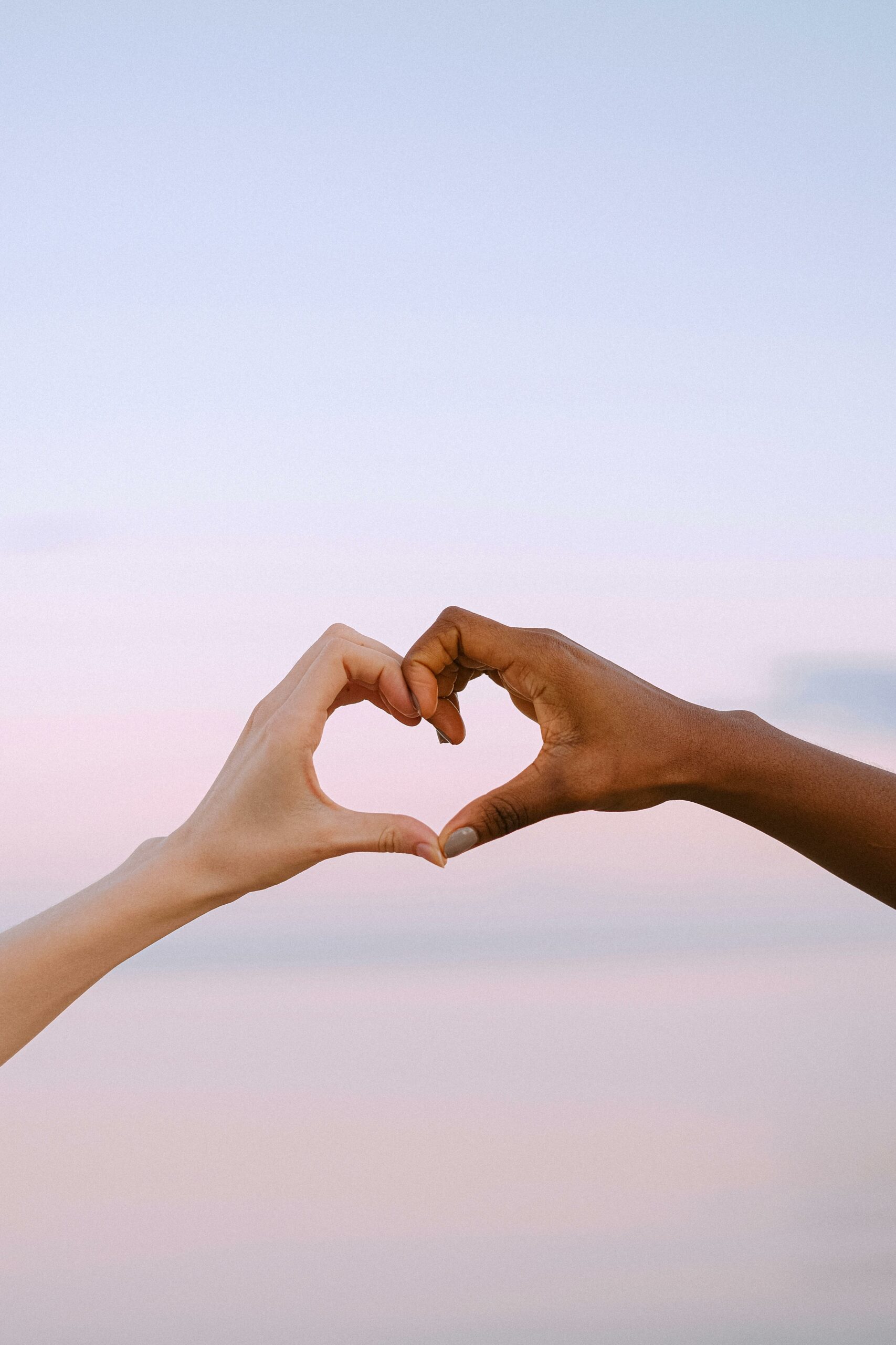 Two persons hands creating a heart. 